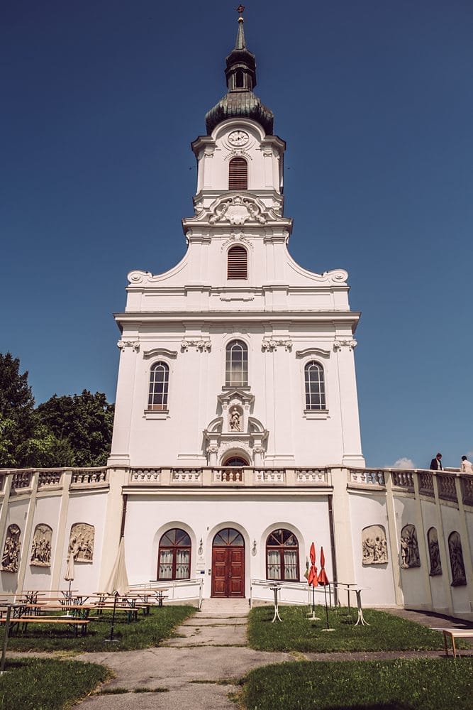 Eine weiße Kirche mit einem Kirchturm im Hintergrund.