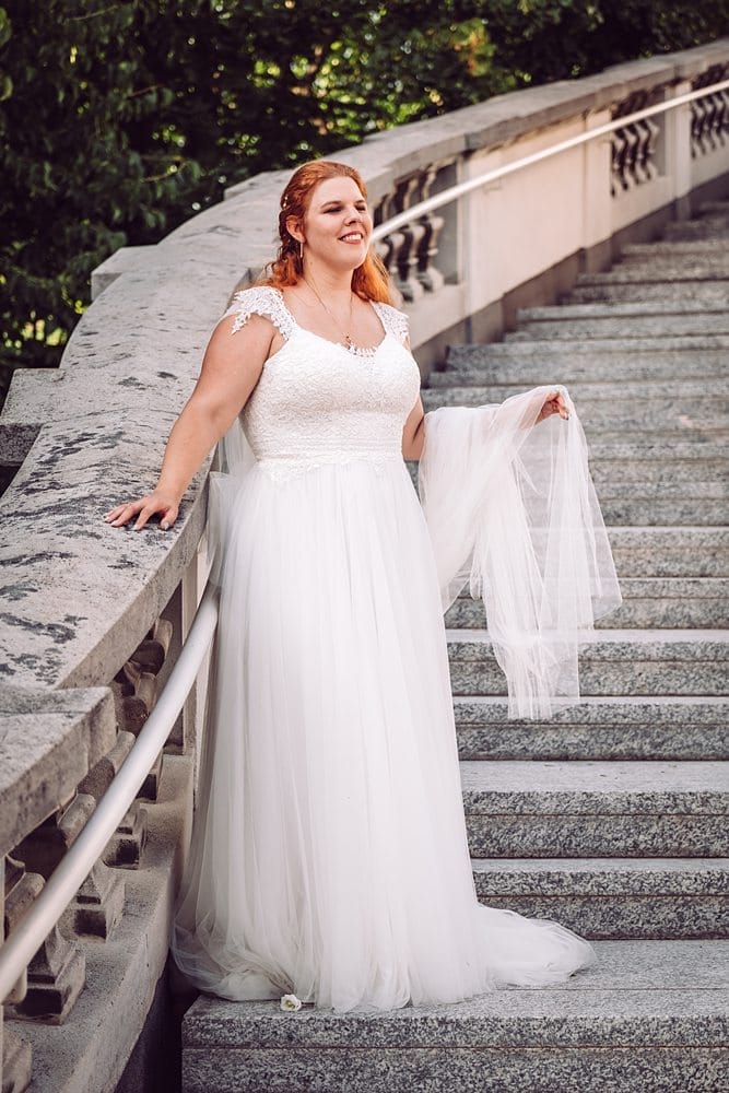 Eine Frau in einem Hochzeitskleid steht auf einer Treppe.