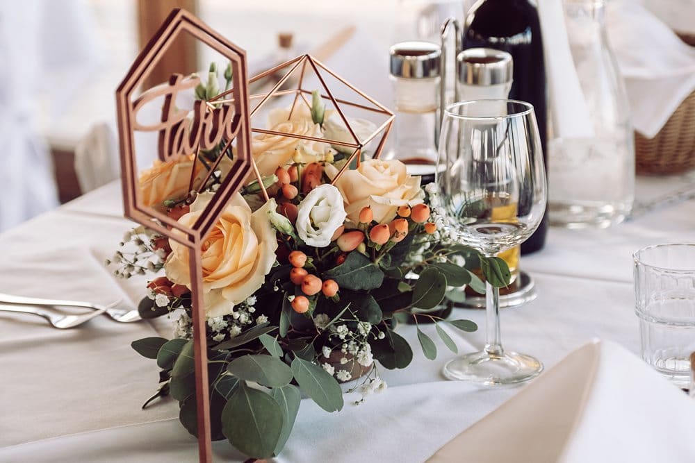 Ein Tischgedeck mit Blumen und einer Tischnummer.