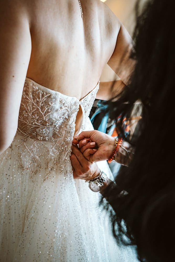Eine Braut zieht ihr Hochzeitskleid an.