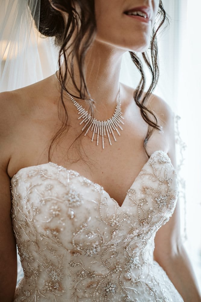 Eine Braut in einem Hochzeitskleid mit einer Halskette.