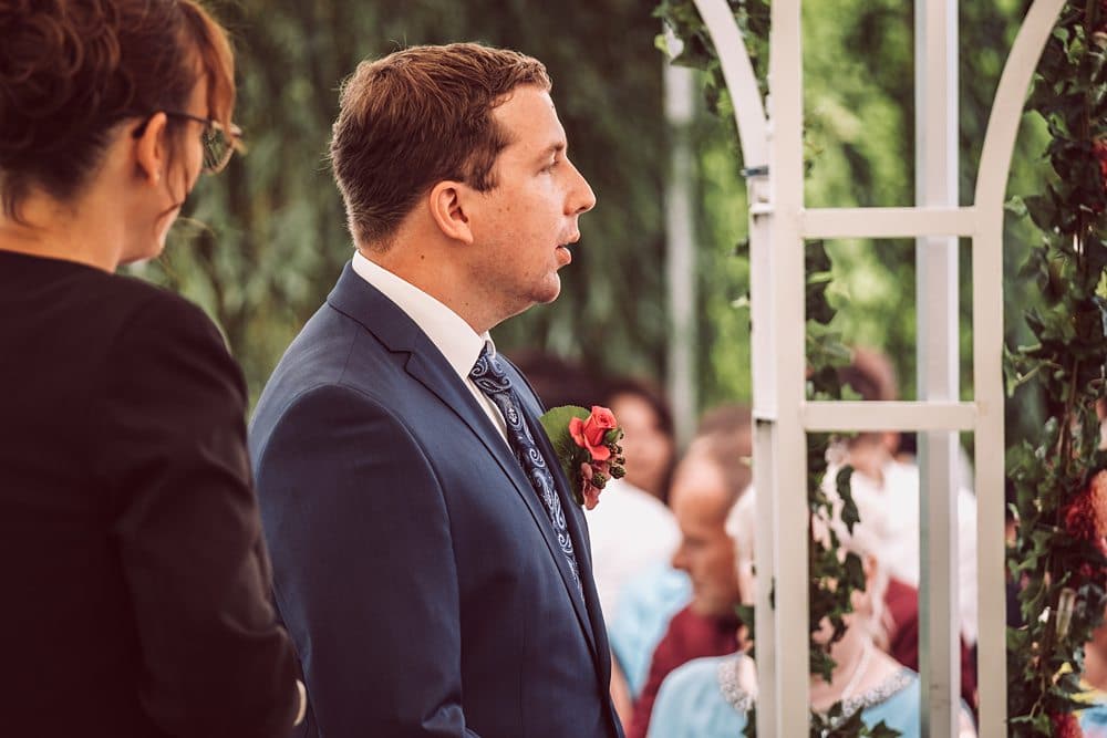 Eine Braut und ein Bräutigam schauen sich während einer Hochzeitszeremonie an.