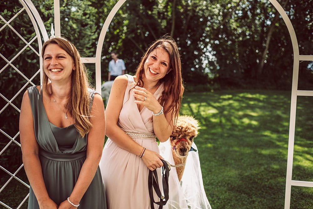 Zwei Brautjungfern lächelnd vor einem Bogen.