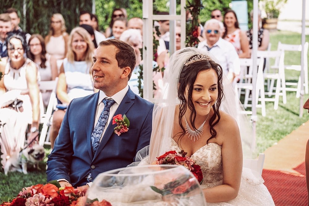 Eine Braut und ein Bräutigam lächeln sich während ihrer Hochzeitszeremonie an.