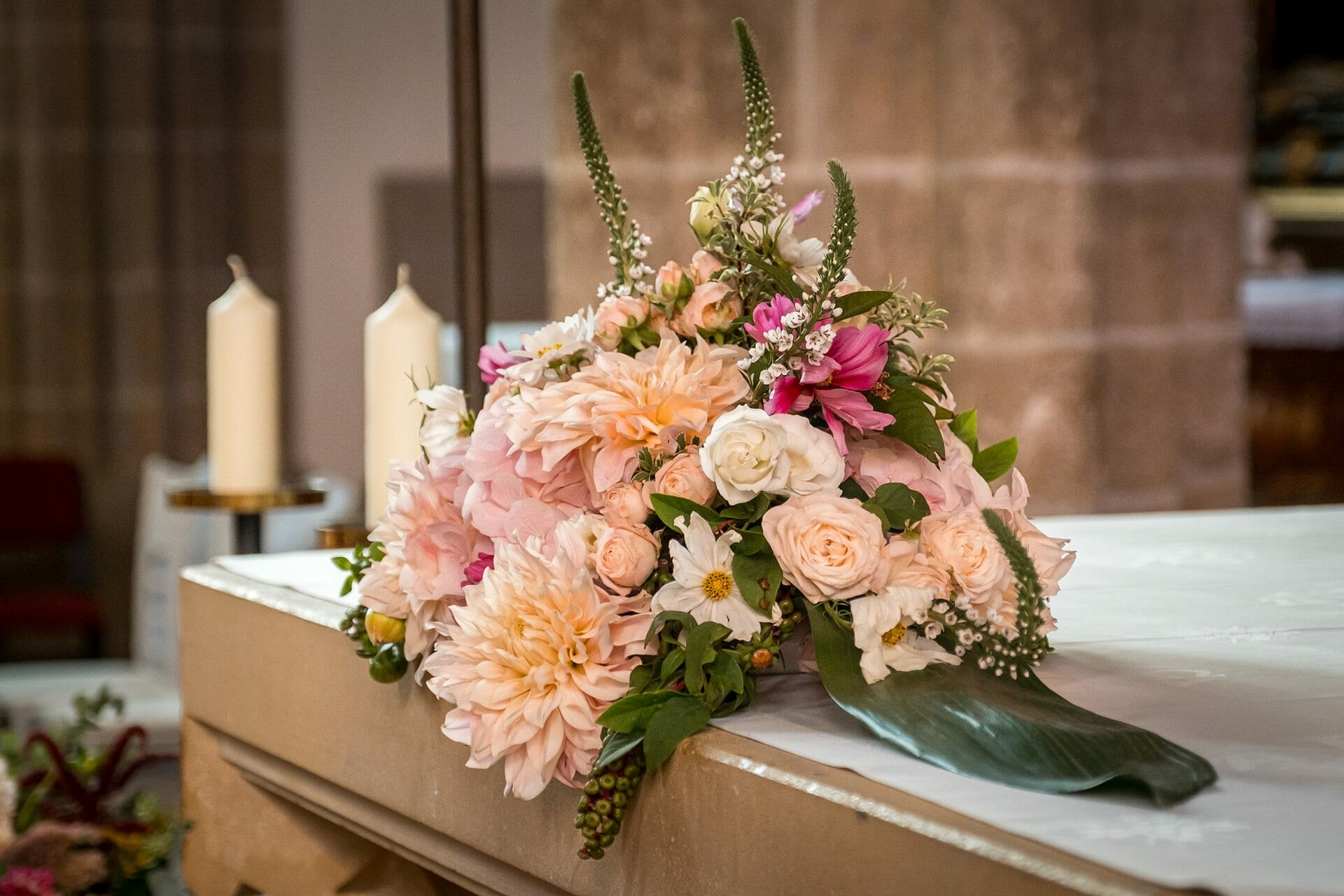 Ein Blumenstrauß steht auf einem Tisch in einer Kirche.