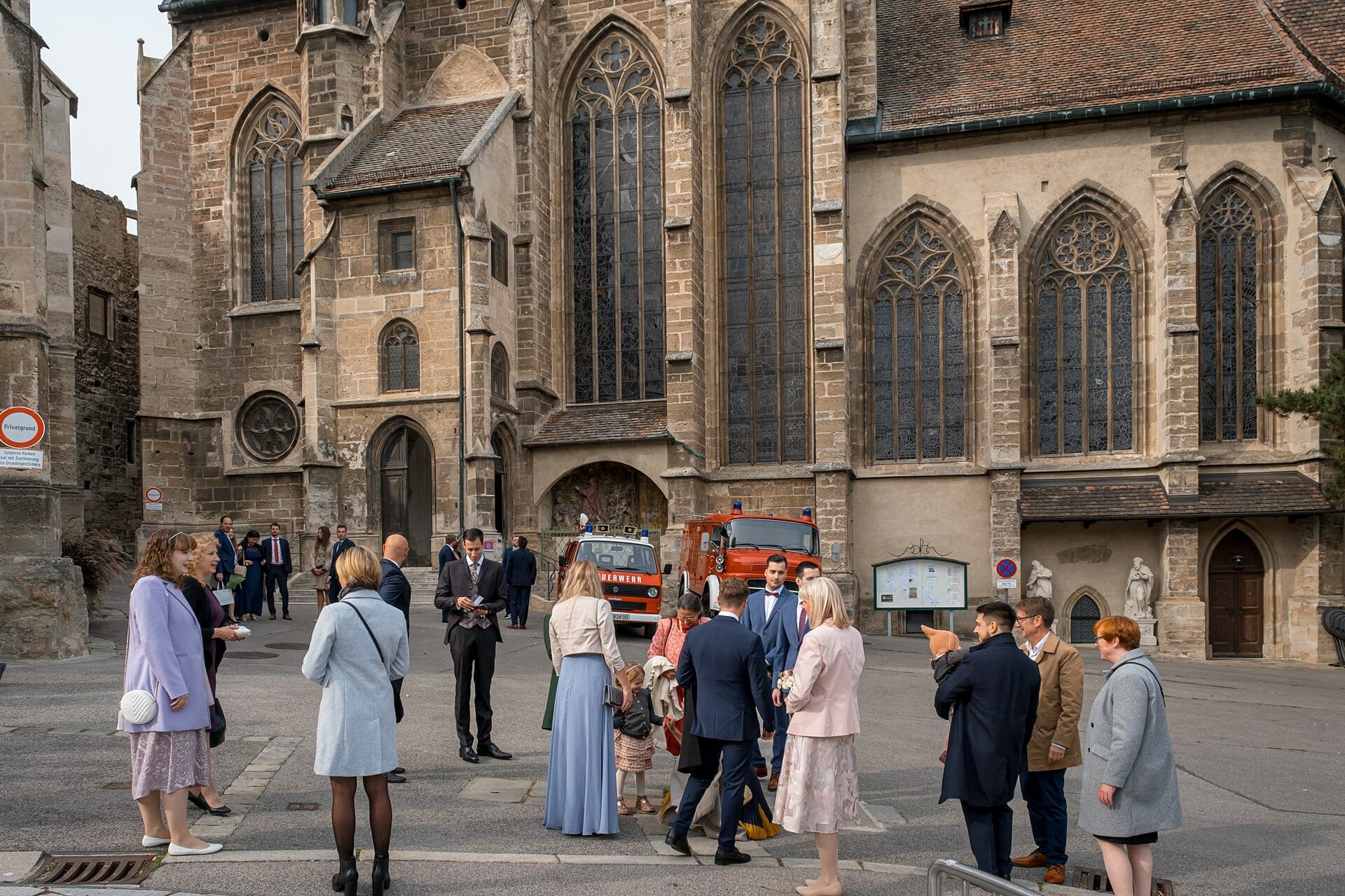 Eine Gruppe von Menschen steht vor einer Kirche.