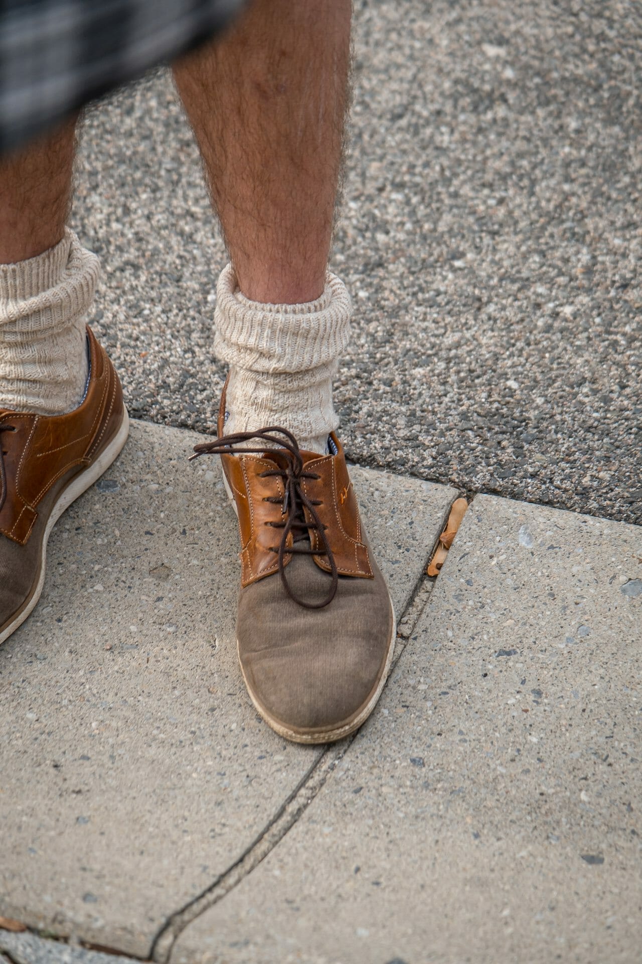 Ein Mann trägt ein Paar braune Schuhe und Socken.