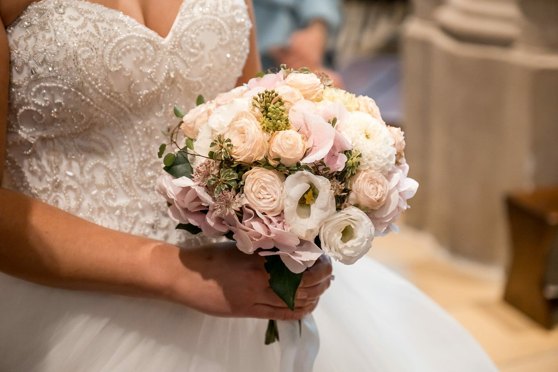 Eine Braut in einem Hochzeitskleid, die einen Blumenstrauß hält.