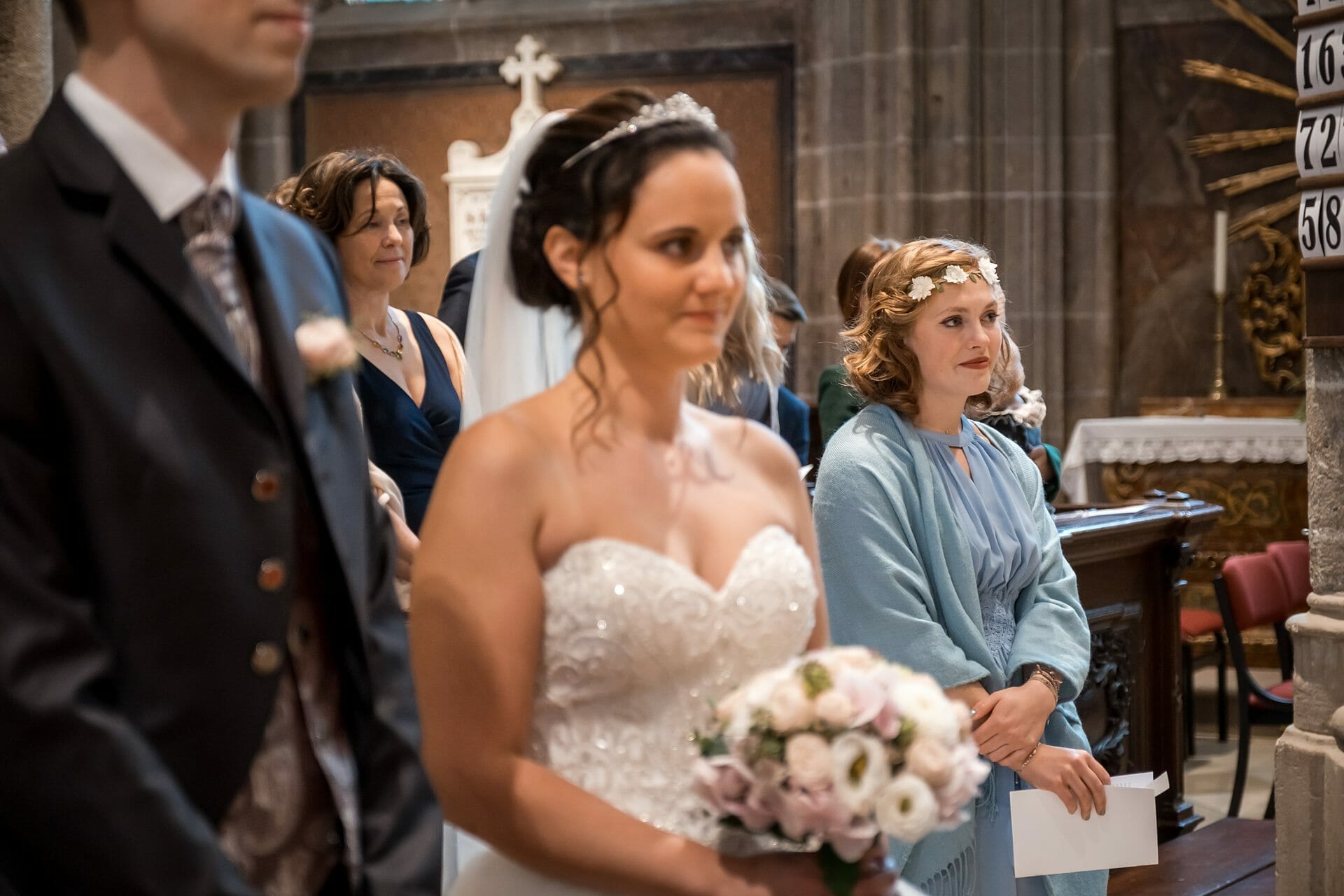 Eine Braut und ein Bräutigam gehen in einer Kirche den Altar entlang.