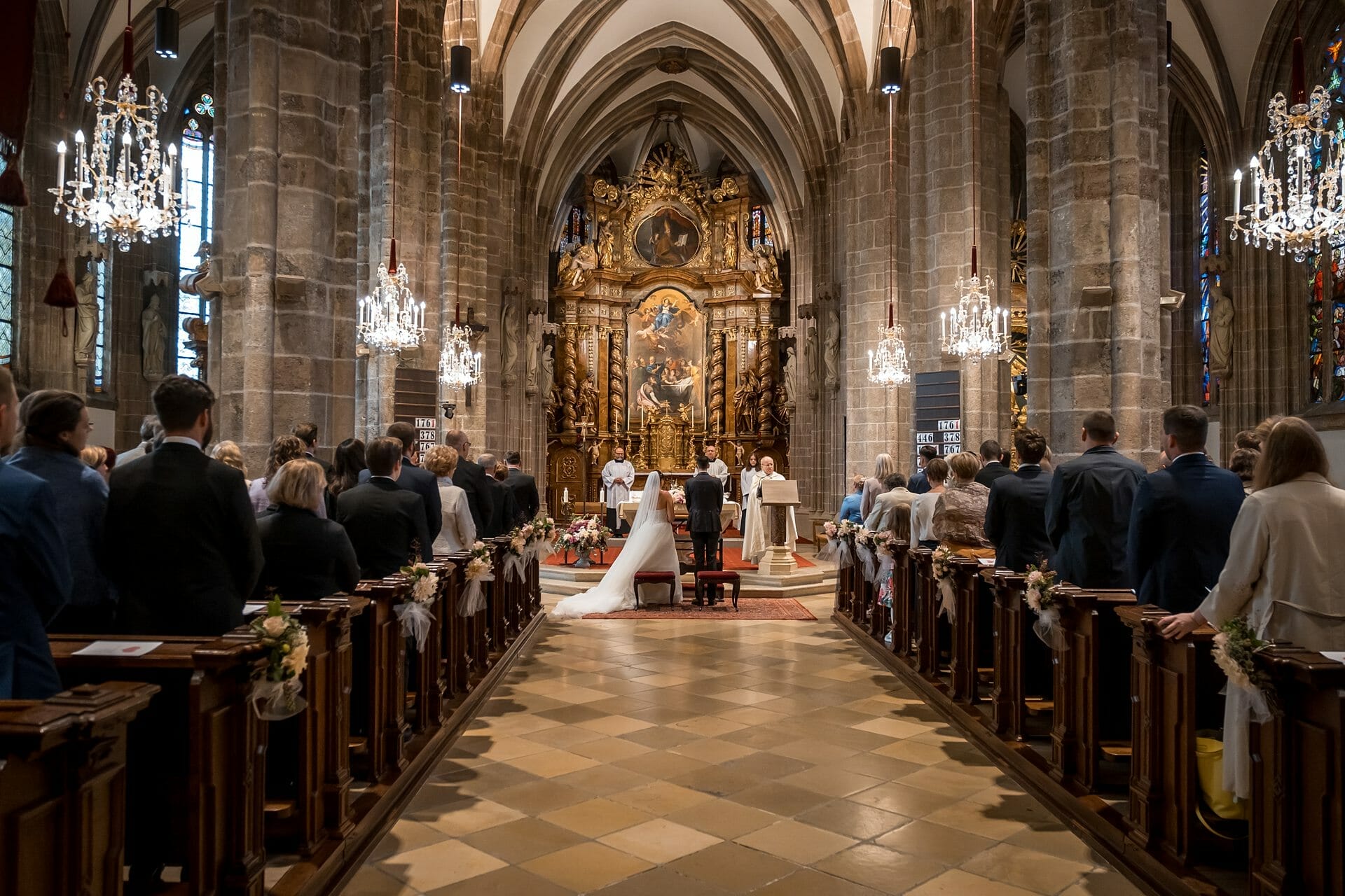 Eine Hochzeitszeremonie in einer Kirche, bei der Braut und Bräutigam den Gang entlanggehen.