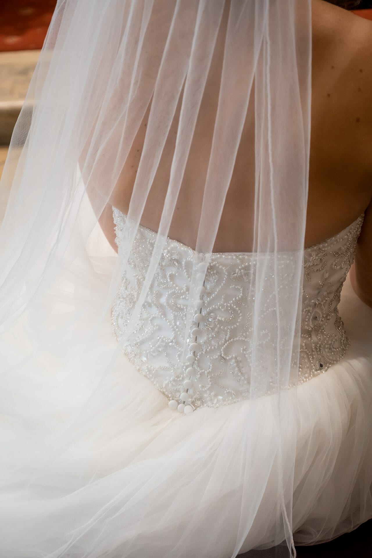 Der Rücken einer Braut in einem Hochzeitskleid.