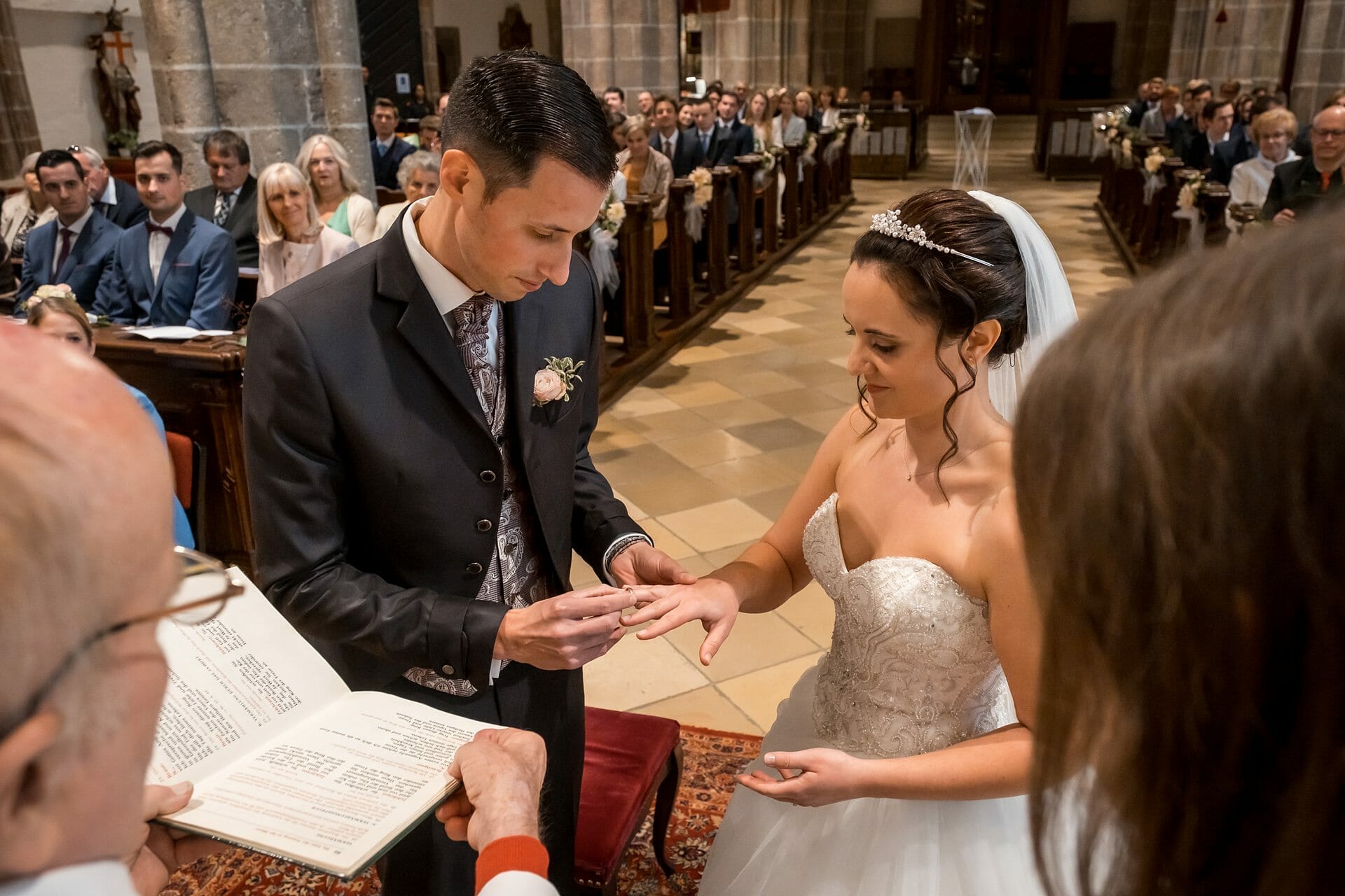 Ein Brautpaar tauscht in einer Kirche die Ringe aus.