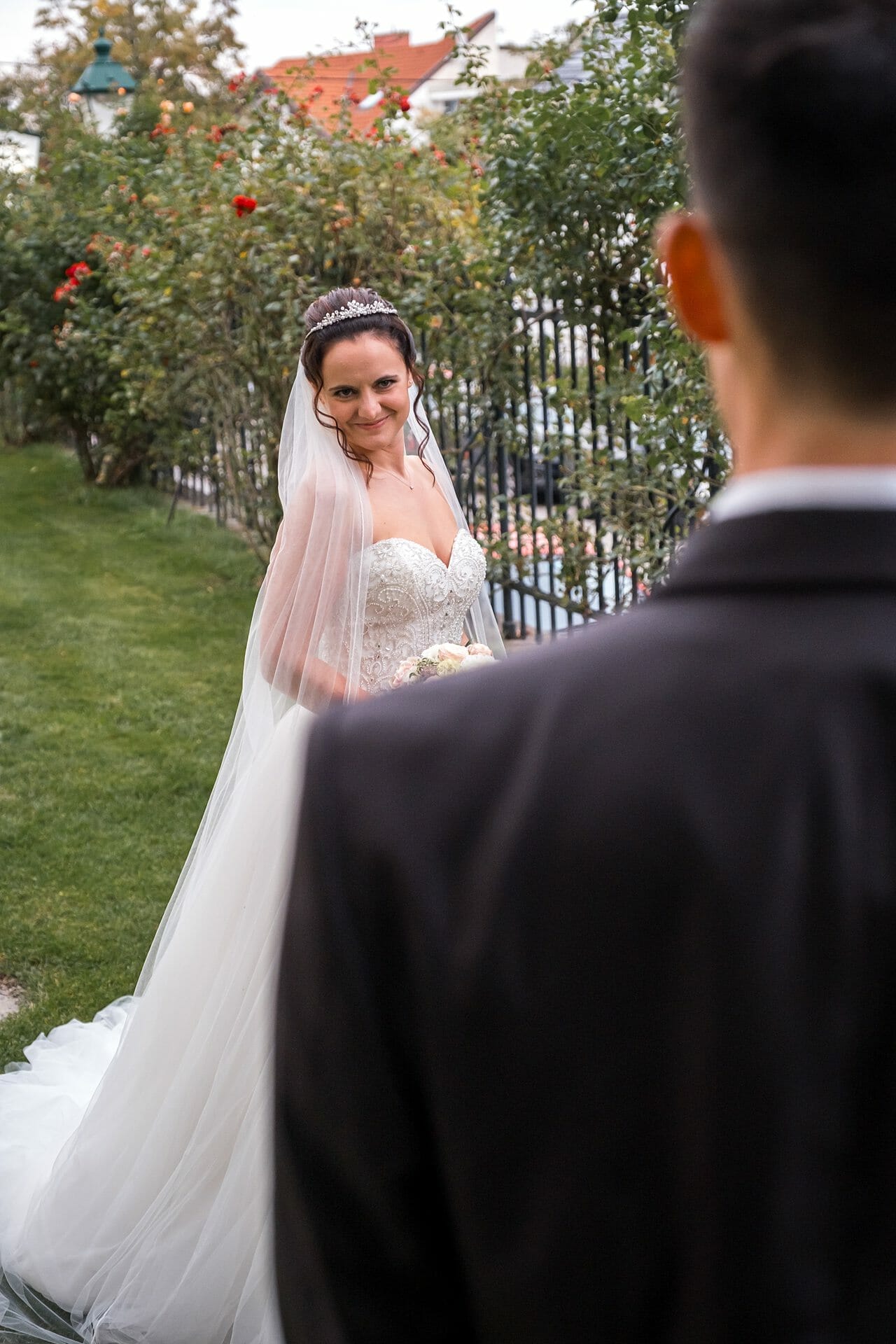 Eine Braut und ein Bräutigam schauen sich in einem Garten an.