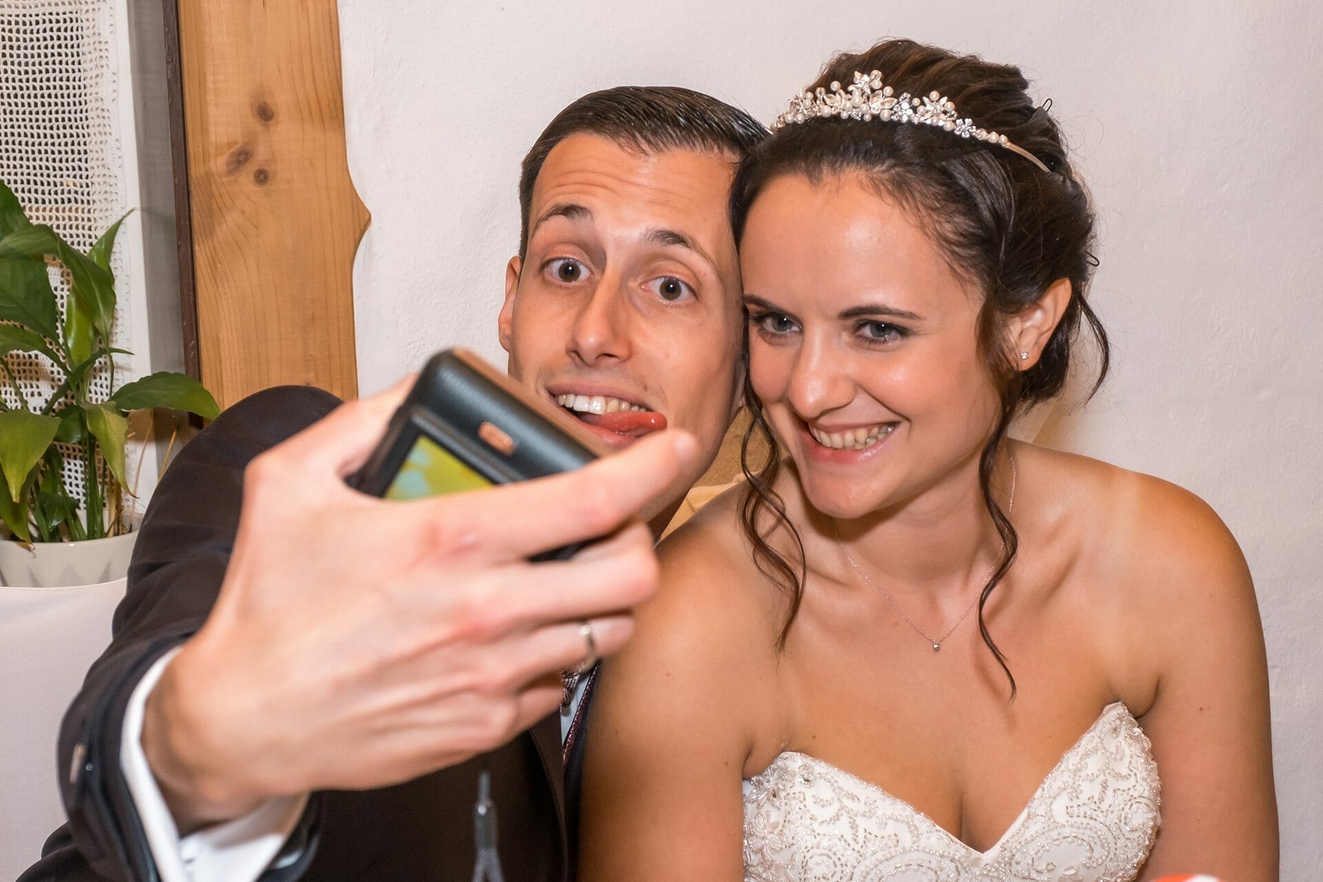 Eine Braut und ein Bräutigam machen ein Selfie mit ihrem Handy.