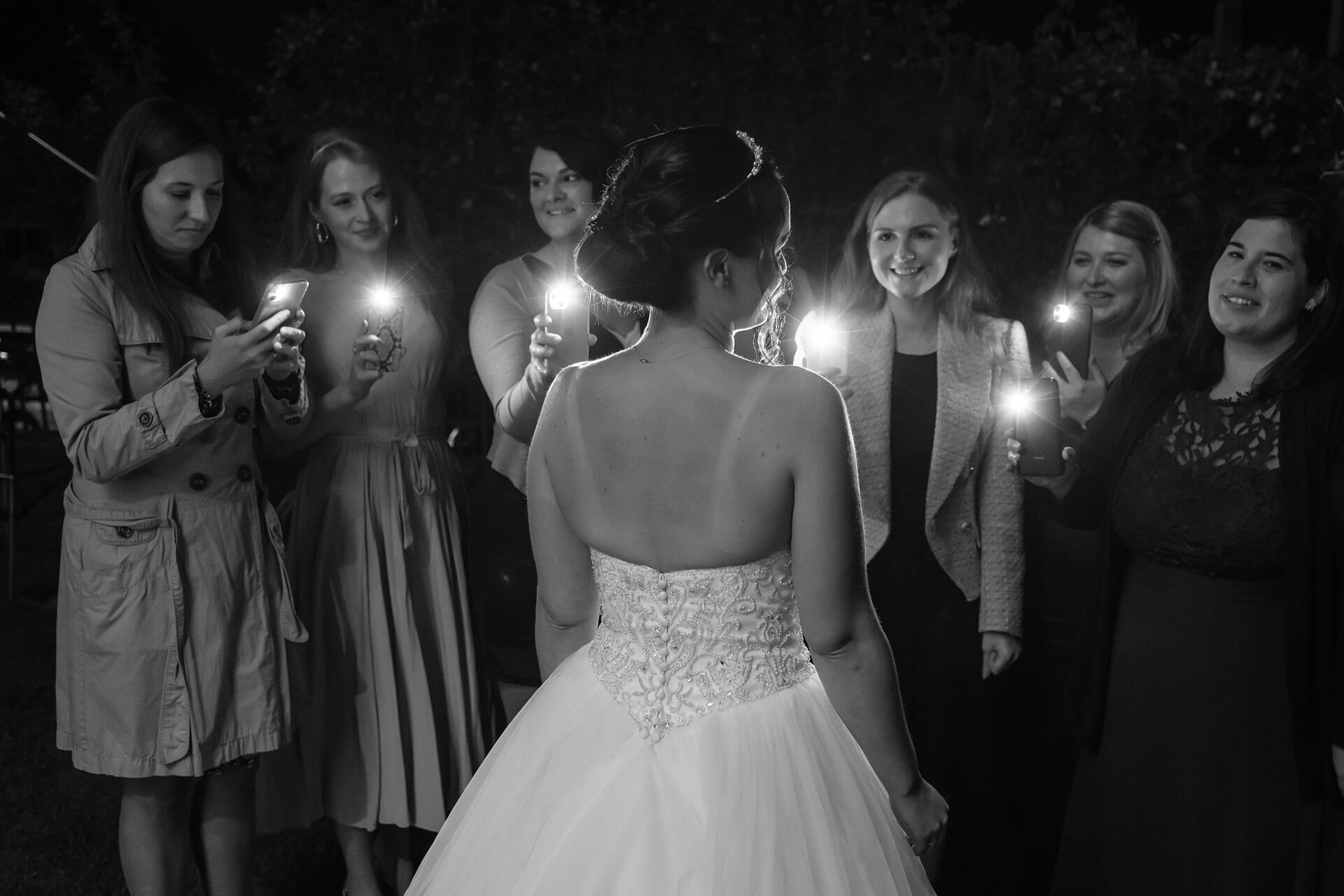 Eine Braut mit ihren Brautjungfern, die Kerzen halten.