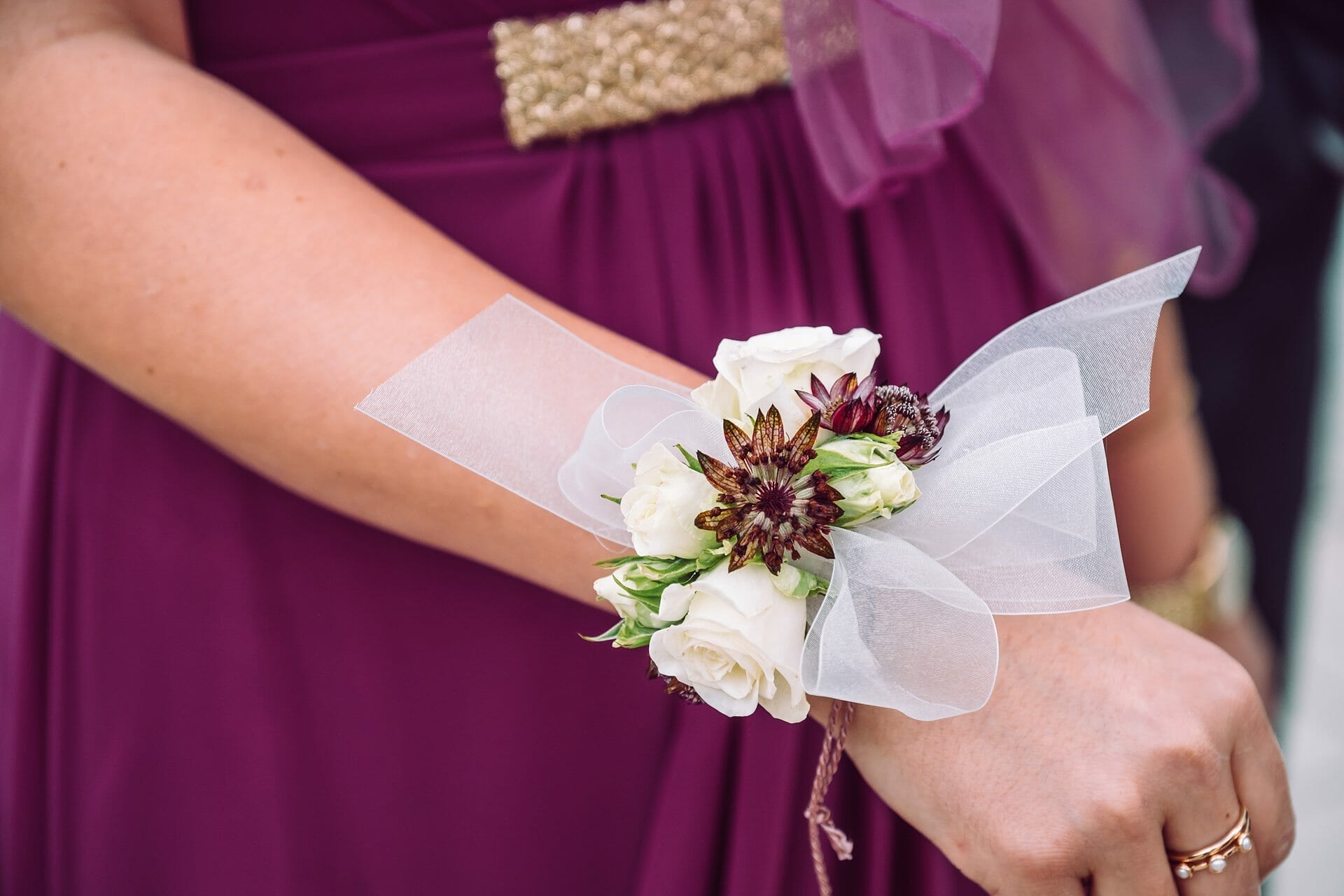 Eine Frau trägt ein lila Kleid mit einer Blumenkorsage.